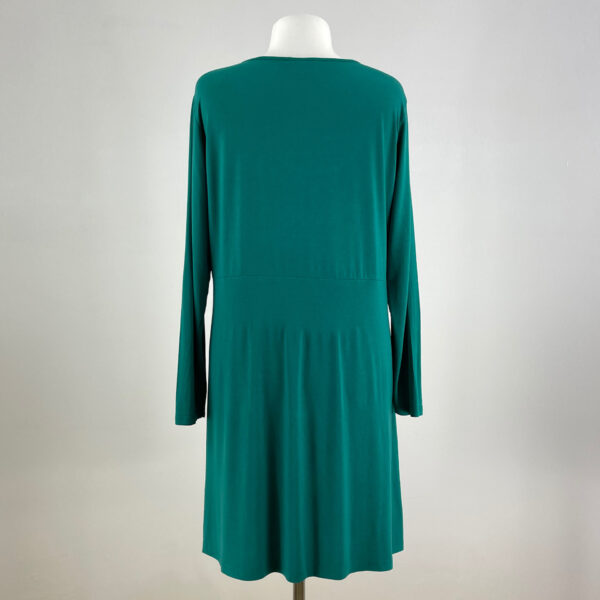 Zielona sukienka z długimi rękawami. Dekolt okrągły i dość głęboki. Wykonana z rozciągliwego materiału. Sięga mniej więcej do kolan. Na metce rozmiar 48/50. Stan idealny - wygląda na nieużywaną.