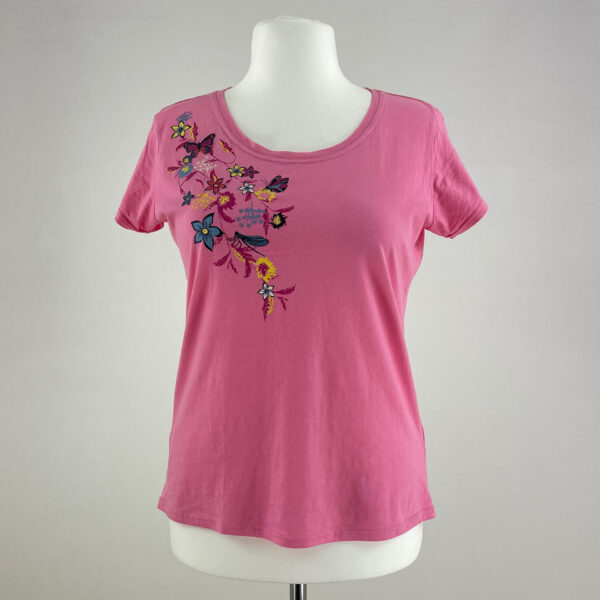 Różowa koszulka damska z krótkim rękawem. Dekolt okrągły. Z przodu ozdobiona niewielkim obrazkiem z kwiatami i motylami.