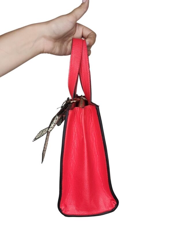 Czerwona torebka z imitacją skóry. Ozdobna kokardka przy rączce.